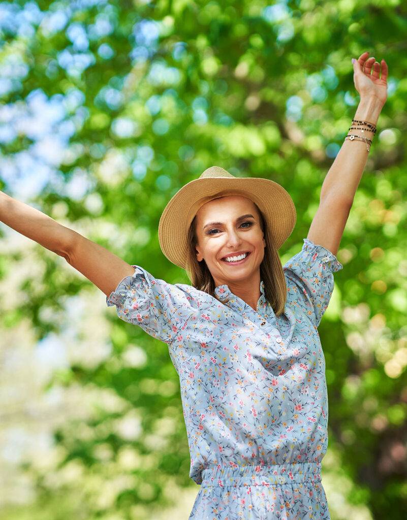 Woman jumping for joy on a sunny day after recieving hormone replacement therapy