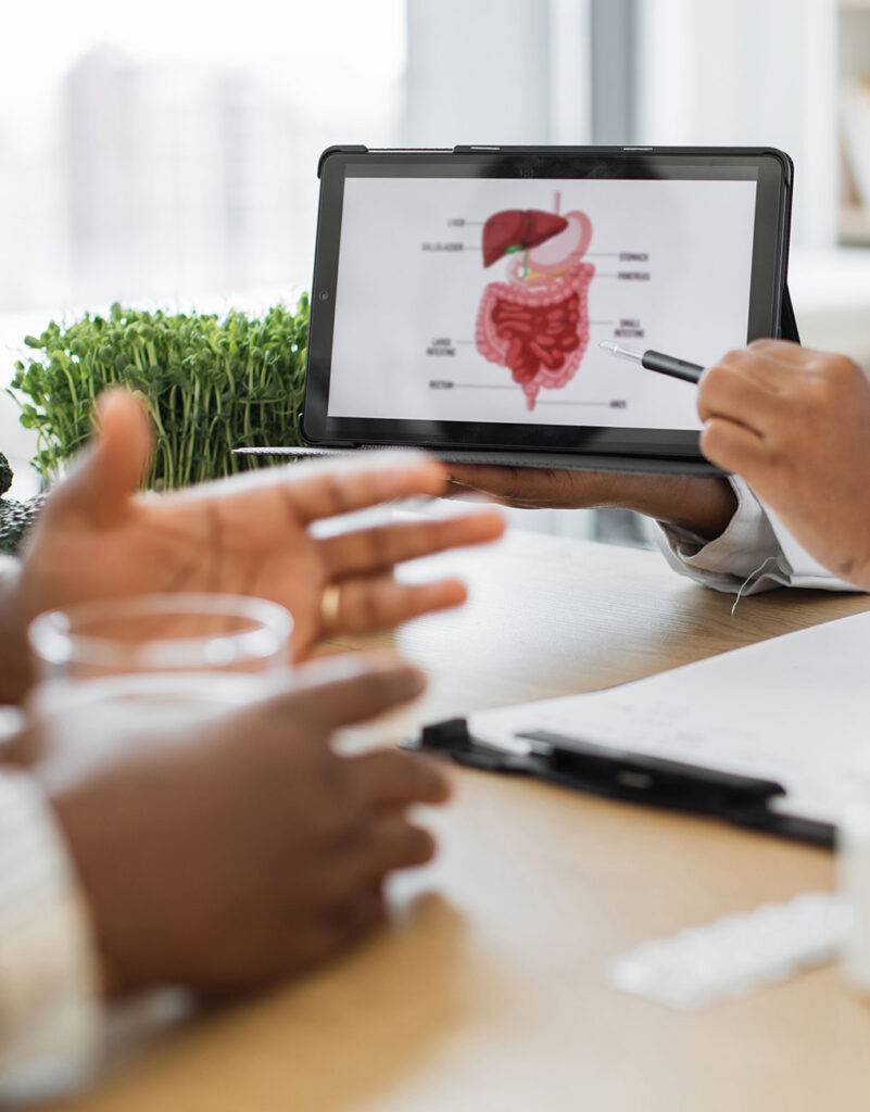 Nurse practiotioner pointing to GI track image on screen showing patient information