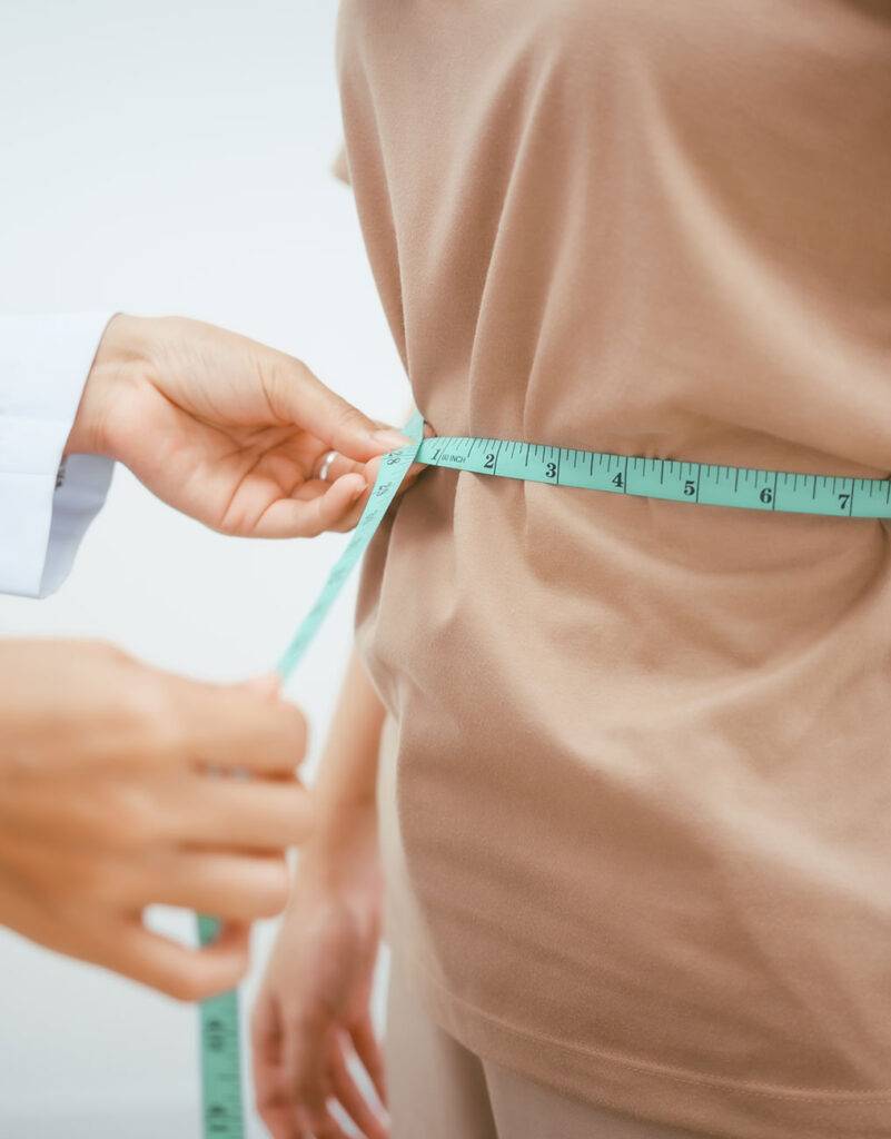 Nurse Practiotioner measuring patient waist line after medical weight loss