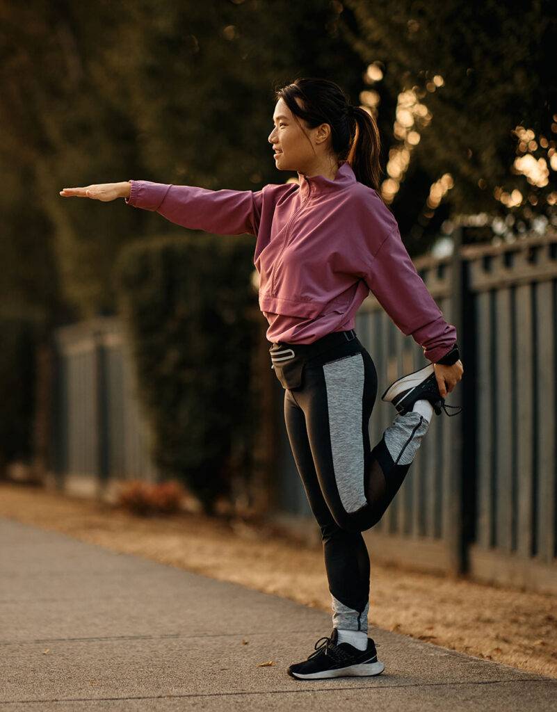 Patient stretching leg with athletic clothes on in residential neighborhood